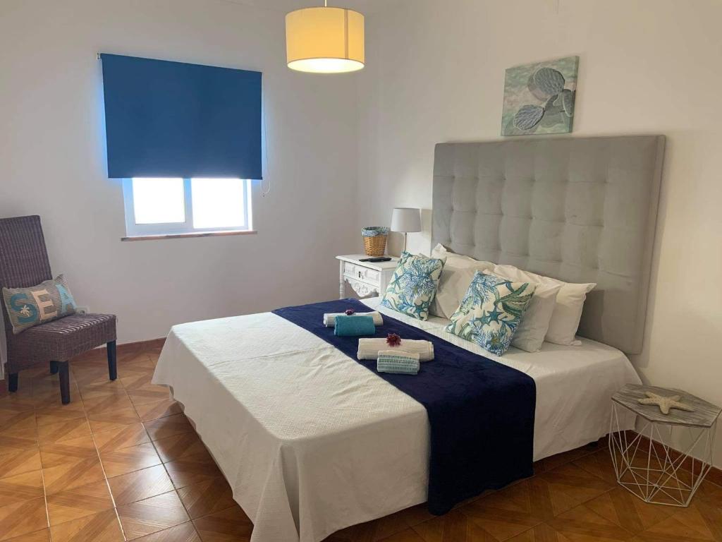 ein Schlafzimmer mit einem großen Bett mit einer blauen Decke in der Unterkunft Vivenda Rosa Lagos in Lagos