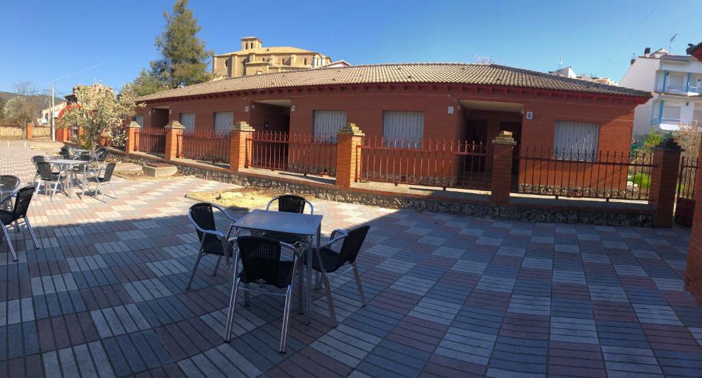 a patio with tables and chairs in front of a building at Apartamentos Buendia in Buendía