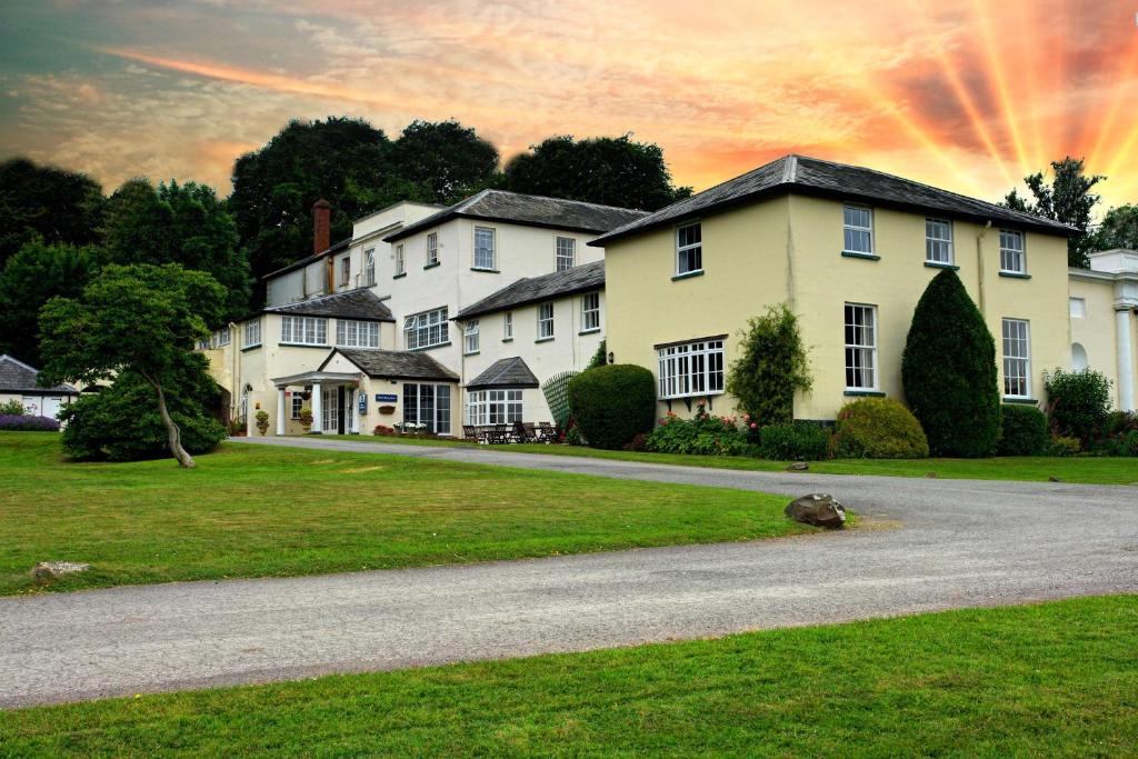 a large house with a driveway in front of it at Best Western Lord Haldon Hotel in Exeter