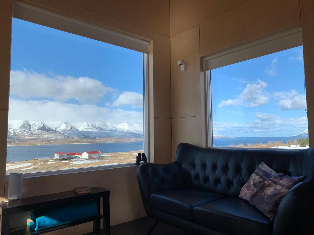 a living room with a couch and a large window at Sunnuhlid houses in Akureyri