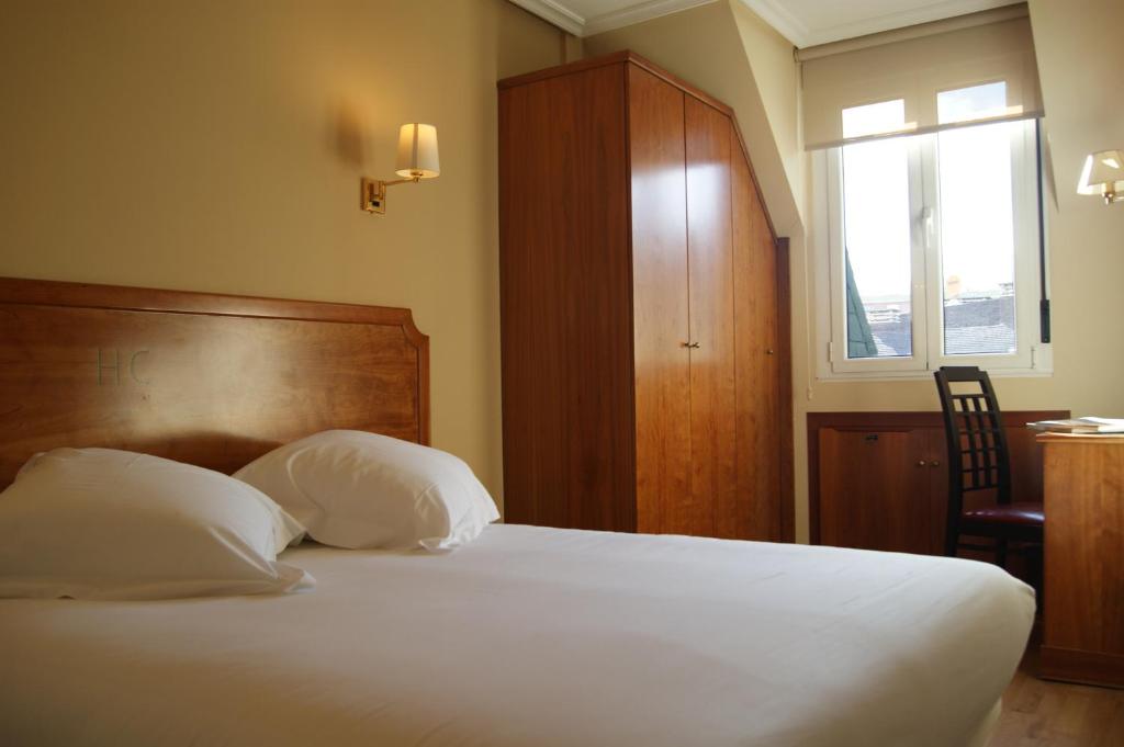 sypialnia z łóżkiem z 2 poduszkami i oknem w obiekcie El Retiro de Cardea w mieście Oviedo