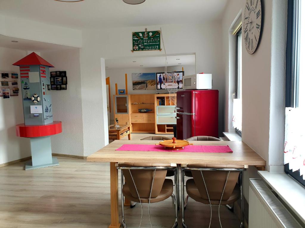 eine Küche mit einem Holztisch und einem roten Kühlschrank in der Unterkunft Nordsee in Wilhelmshaven