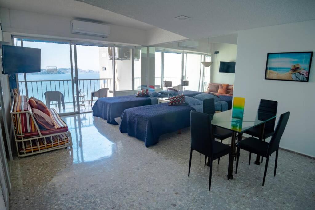 Sala de estar con sofá, cama y mesa en Suite frente al mar en el corazón de Acapulco en Acapulco