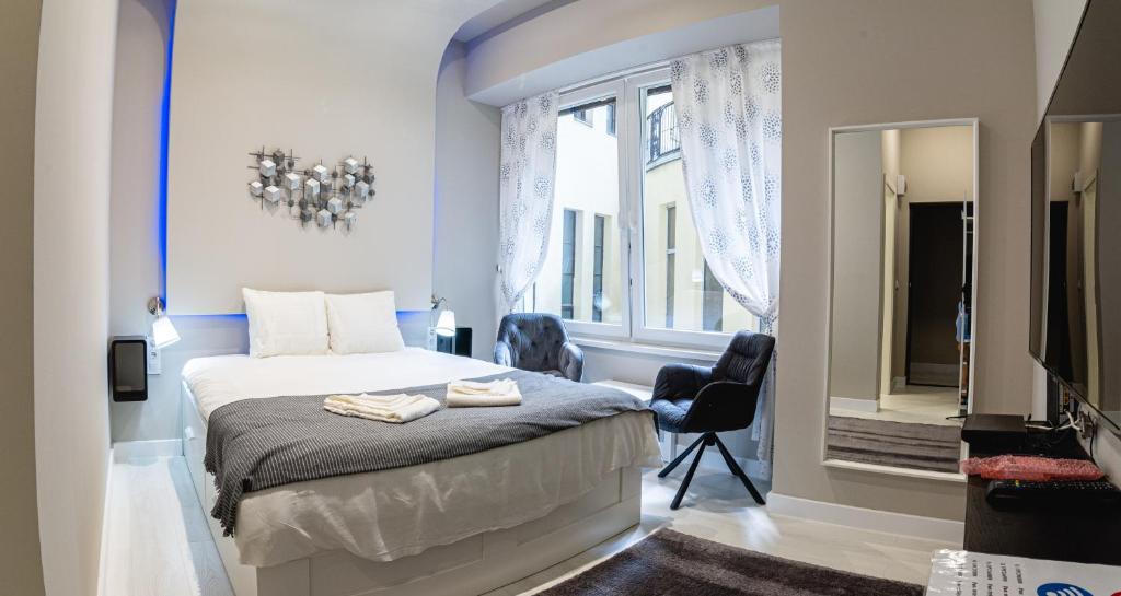 a bedroom with a bed and a window and a mirror at The Royals Downtown in Budapest