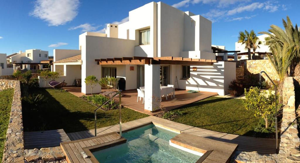 a villa with a swimming pool in front of a house at Villa in Spain at Las Colinas Golf & Country Club in Orihuela Costa