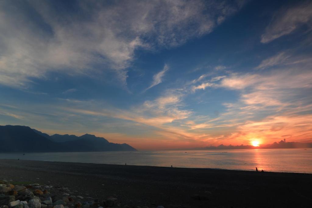 un tramonto su una spiaggia con il tramonto di 七星潭118海景民宿 a Dahan