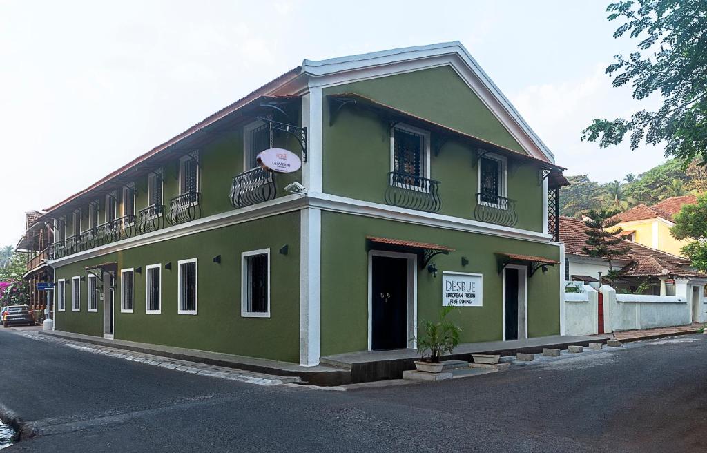 un bâtiment vert sur le côté d'une rue dans l'établissement amã Stays & Trails La Maison Fontainhas, à Panaji