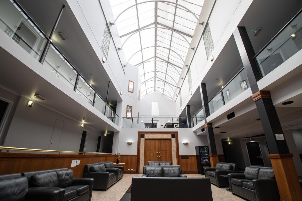 a large lobby with couches and a skylight at Madison Capital Executive Apartments in Canberra