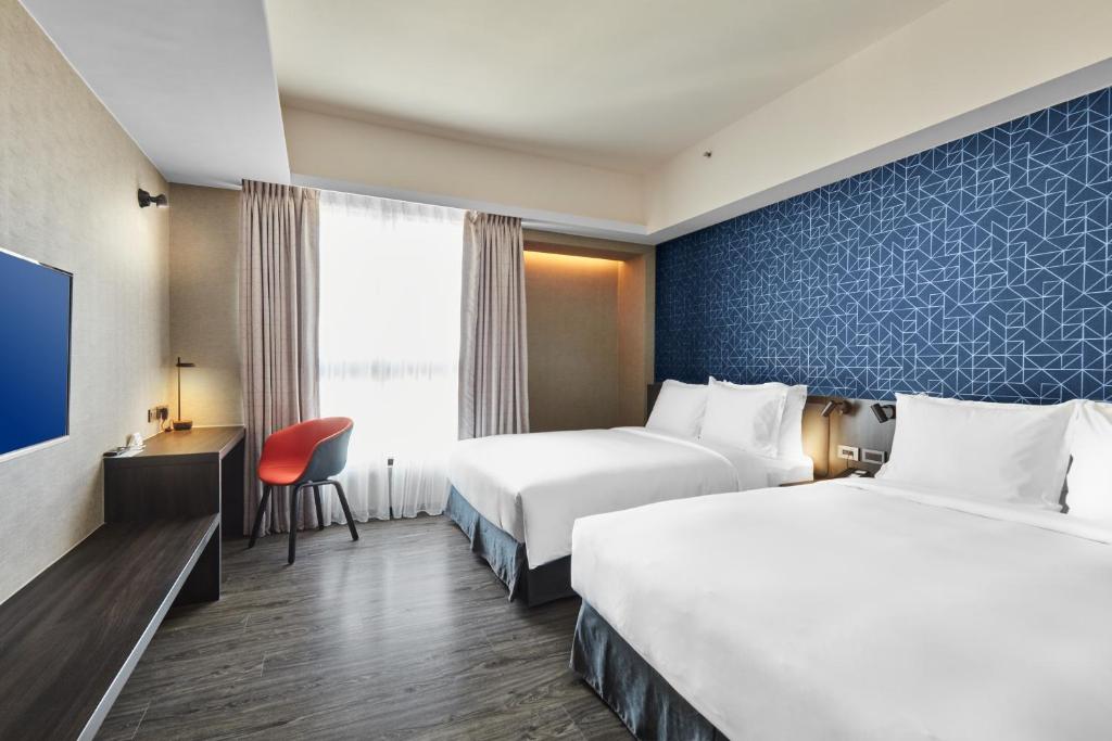 Postel nebo postele na pokoji v ubytování Holiday Inn Express Kaohsiung Love River by IHG