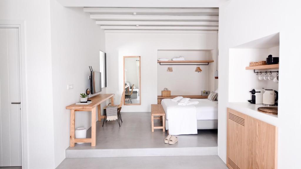 a bedroom with a bed and a desk in a room at Pénde Suites in Livadion