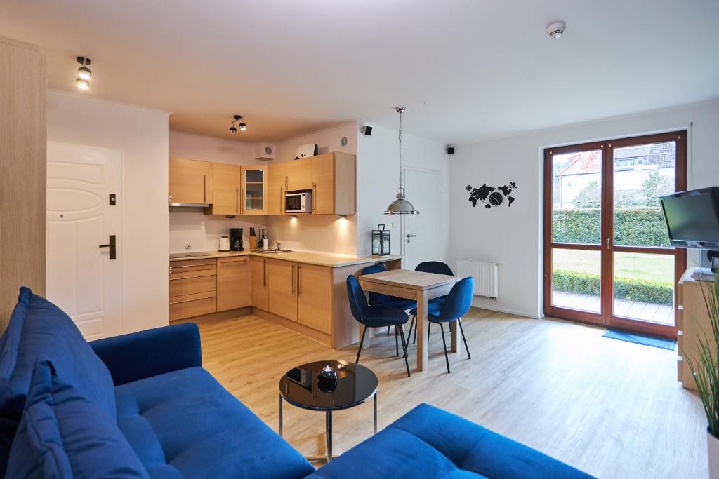 salon z niebieską kanapą i kuchnią w obiekcie Apartamenty Świnoujście - Apartament kapitański Rezydencja Żeromskiego w Świnoujściu