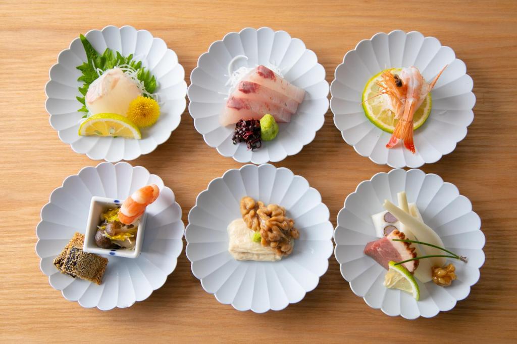 un montón de diferentes tipos de comida en platos de papel en Yufuin Bath Satoyamasafu, en Yufu