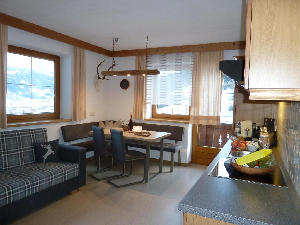 eine Küche und ein Wohnzimmer mit einem Tisch und einem Sofa in der Unterkunft Appartements-Kaltenbach in Kaltenbach