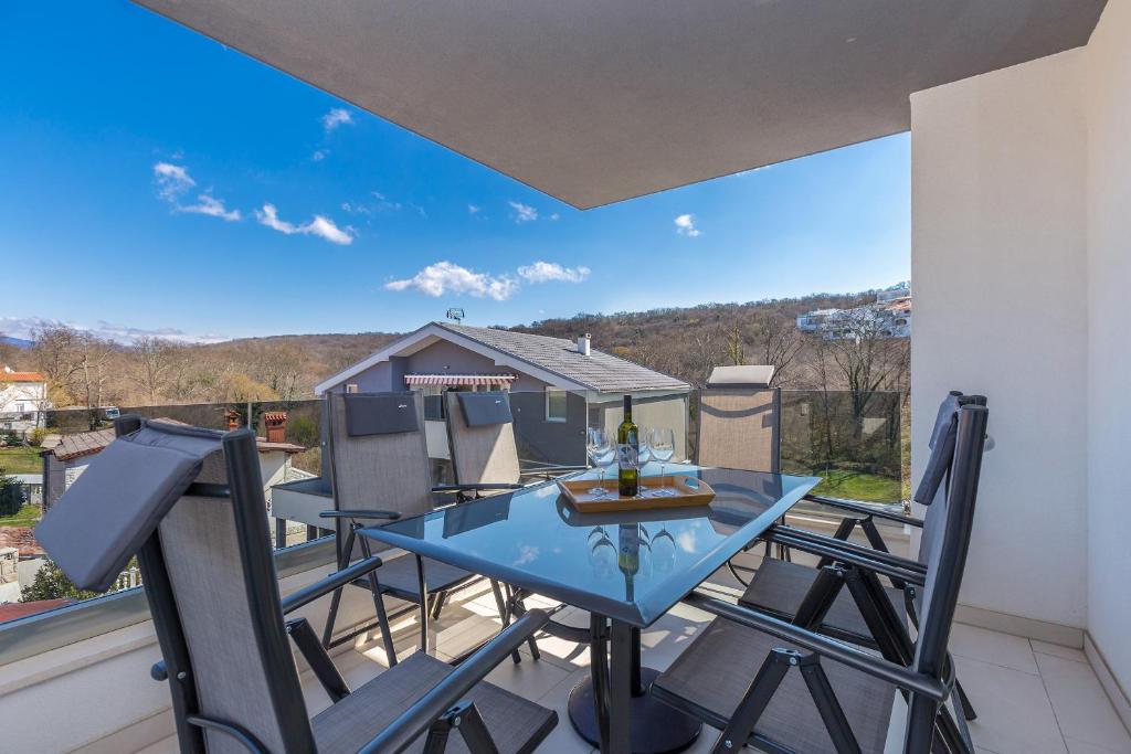 patio ze stołem i krzesłami na balkonie w obiekcie Apartment LAGANINI III w mieście Nijvice