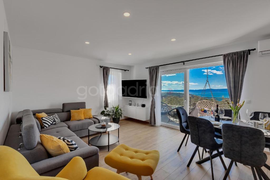 een woonkamer met een bank en een tafel en stoelen bij Luxurious Apartments Lara&Luka in Makarska