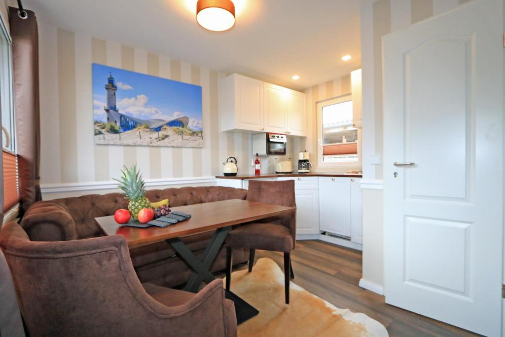 eine Küche und ein Wohnzimmer mit einem Tisch und einem Sofa in der Unterkunft Bungalow-Park Ostseenordstern in Wustrow