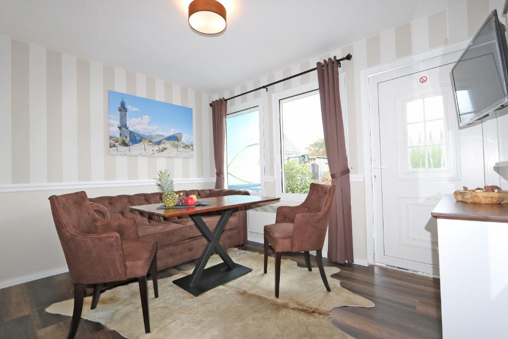 a living room with a couch and a table and chairs at Bungalow-Park Ostseenordstern in Wustrow