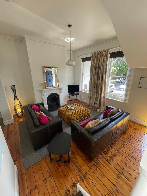 a living room with two couches and a fireplace at Webster Terrace in Ballarat