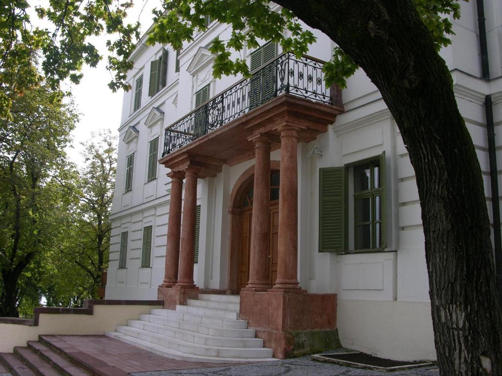 a building with a balcony and stairs in front of it at Horvath Villa Apartman in Balatonfüred