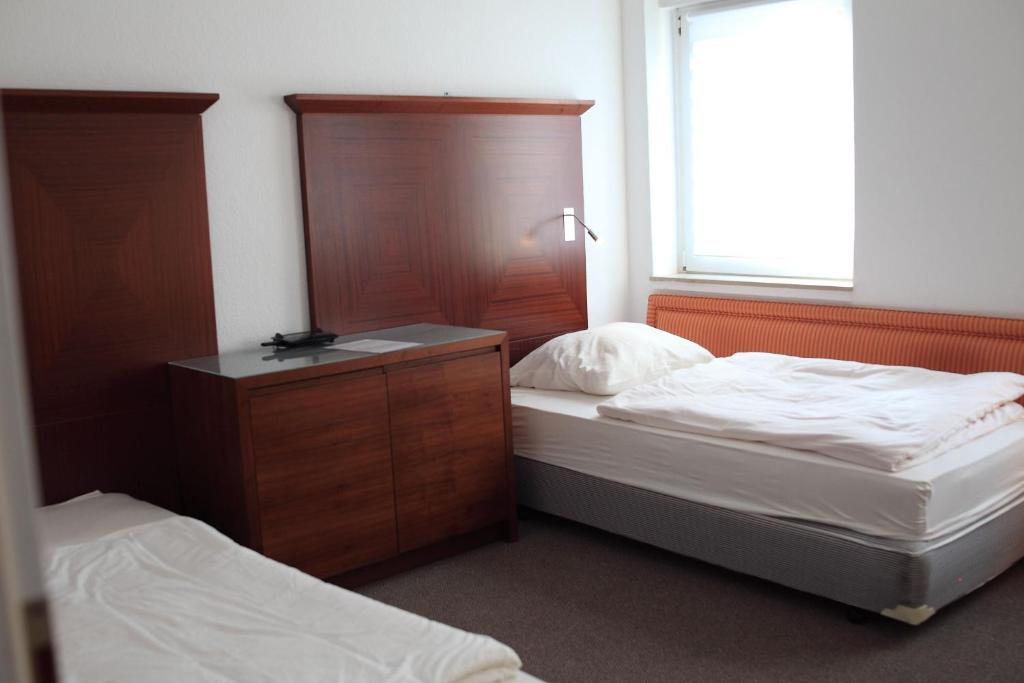 a bedroom with two beds and a dresser and a window at Apartment Spring Creek in Merseburg
