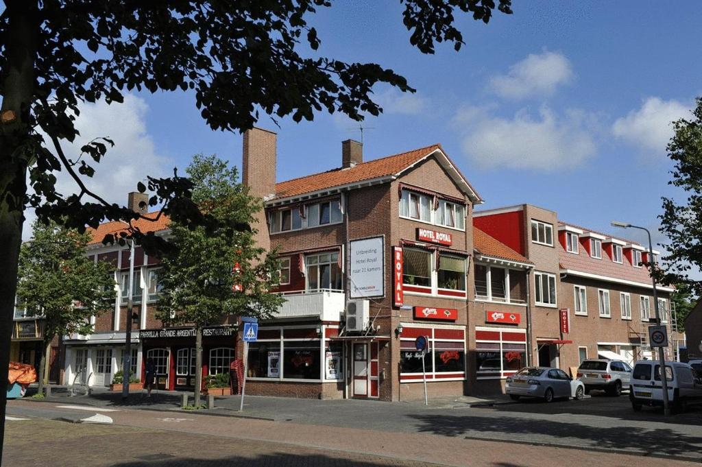 ein Gebäude auf einer Straße mit davor geparkt in der Unterkunft Hotel Royal in IJmuiden