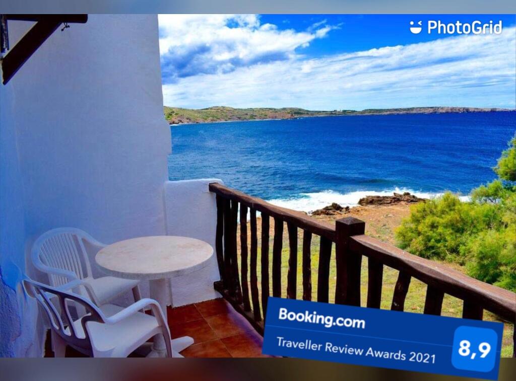 balcone con tavolo, sedie e vista sull'oceano di Apartamento en el mar con terraza a Fornells