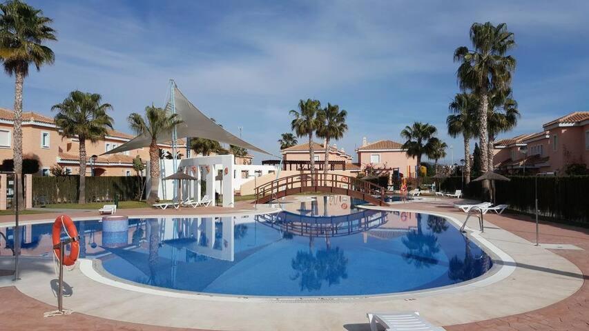 una gran piscina en un complejo con palmeras en El apartamento que buscas Vera Playa, en Los Amarguillos