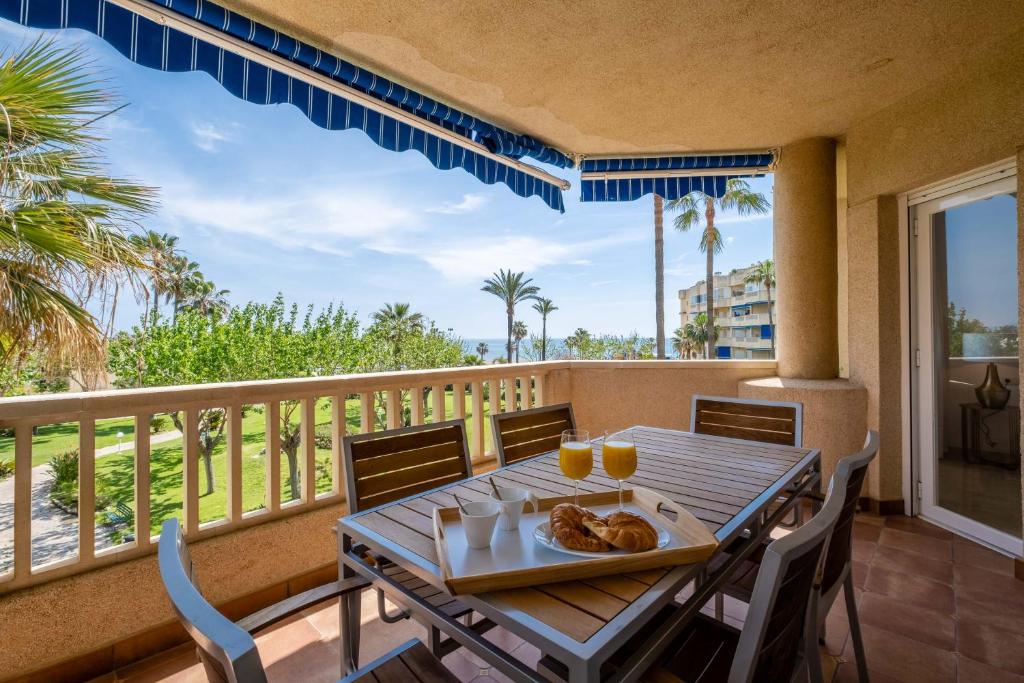 una mesa con un plato de comida en el balcón en Garden & Beach - Torremolinos en Torremolinos