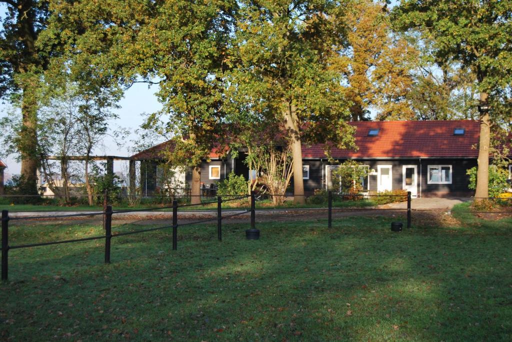 una casa con una valla delante de un patio en Hoeve de Heemser Parel en Heemserveen