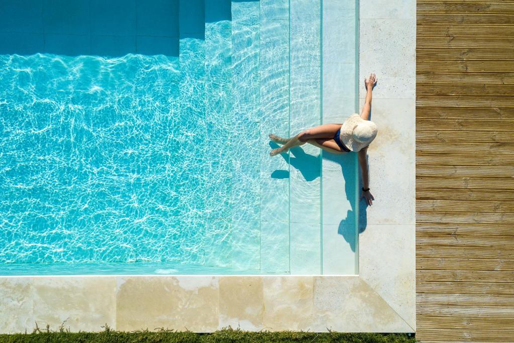 a person is on the side of a swimming pool at Villa Theano in Triopetra