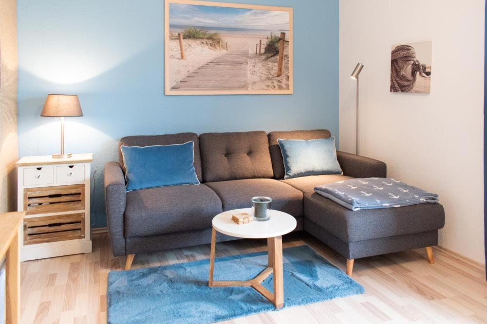 ein Wohnzimmer mit einem Sofa und einem Tisch in der Unterkunft Ferienwohnung Strandterrasse in Haffkrug