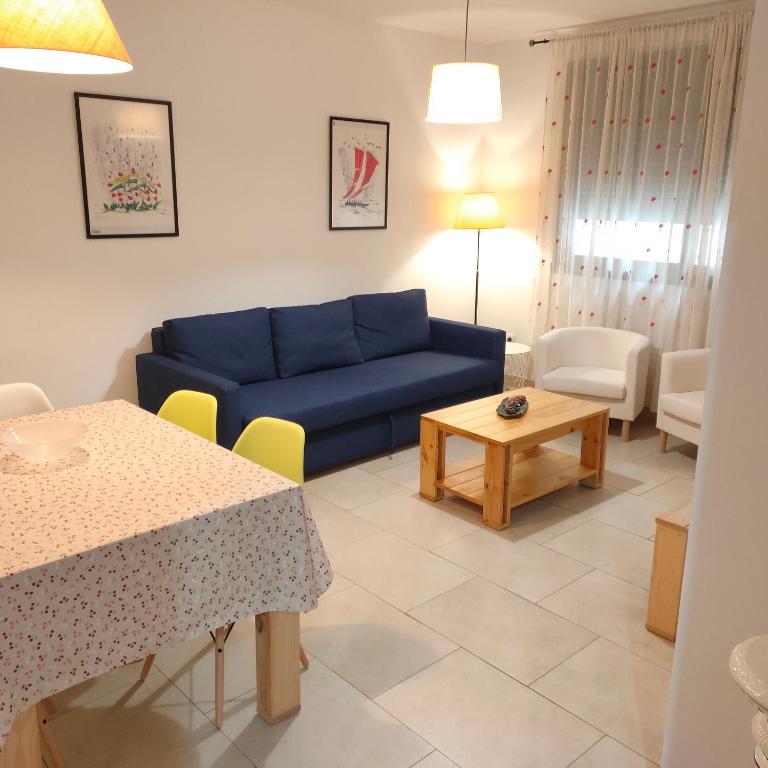 a living room with a blue couch and a table at Apartamento en el centro in Reus