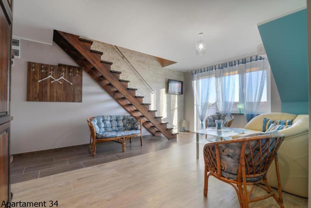 a living room with a staircase and a couch at Apartamenty Rybacka 84B m34 in Krynica Morska