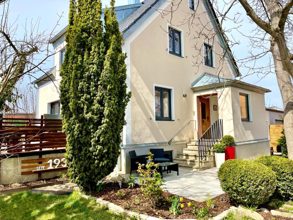 a white house with a tree at The Villetta in Petershausen