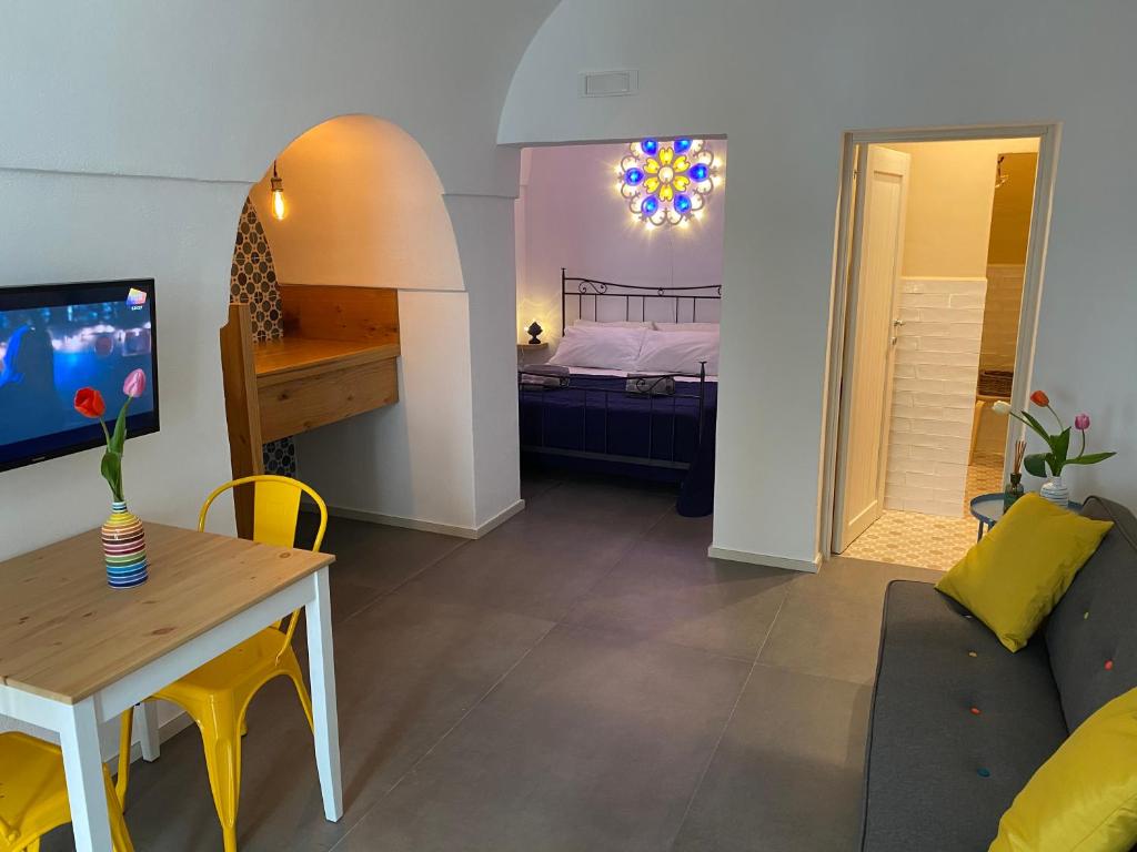 een woonkamer met een bank, een tafel en een bed bij Via Roma 181 in Polignano a Mare