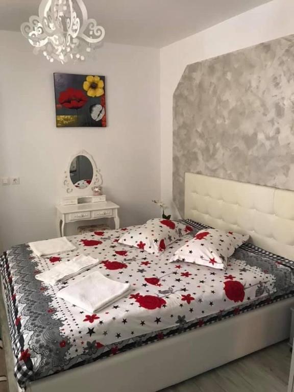 a bedroom with a bed with red flowers on it at Unser Haus in Sibiu