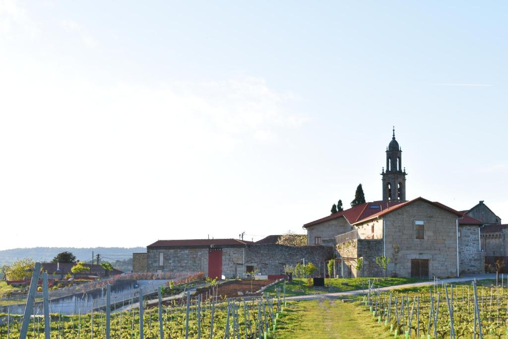 un antiguo edificio con una iglesia y un viñedo en CASA RECTORAL DE SAN EUSEBIO en Ourense