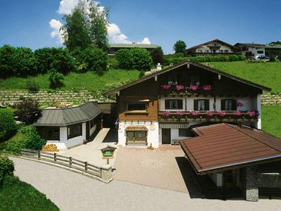 een groot huis met een dak in een tuin bij Gästehaus Hanauerbichl in Schönau am Königssee
