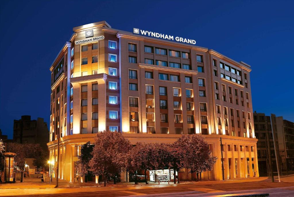 a building with a sign on the top of it at Wyndham Grand Athens in Athens