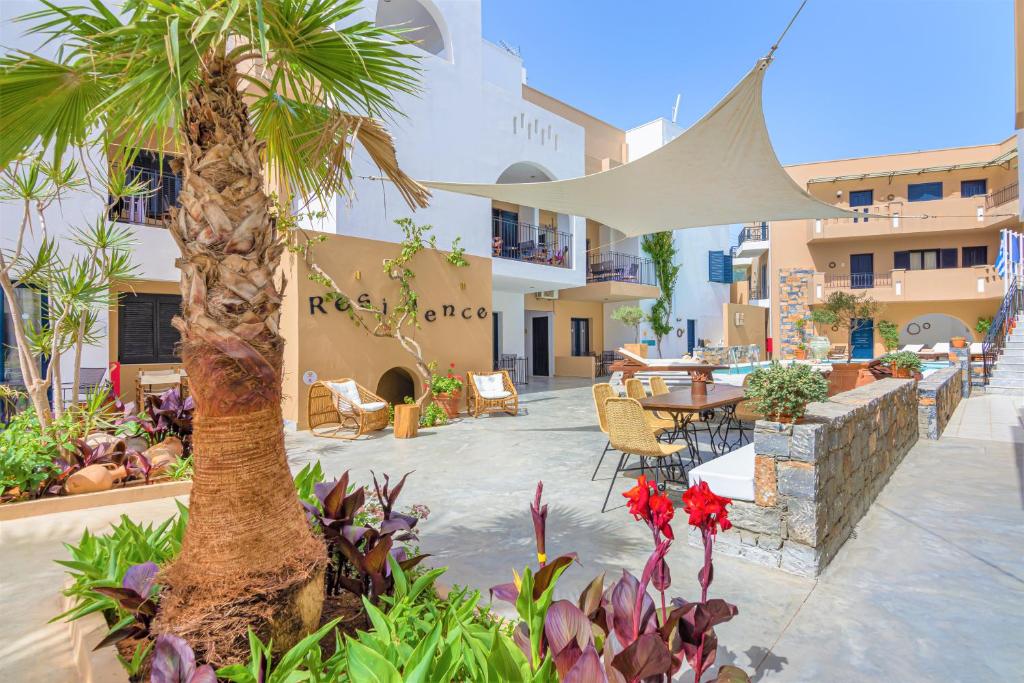 a patio with a table and a palm tree at Residence Villas by Estia in Stalida