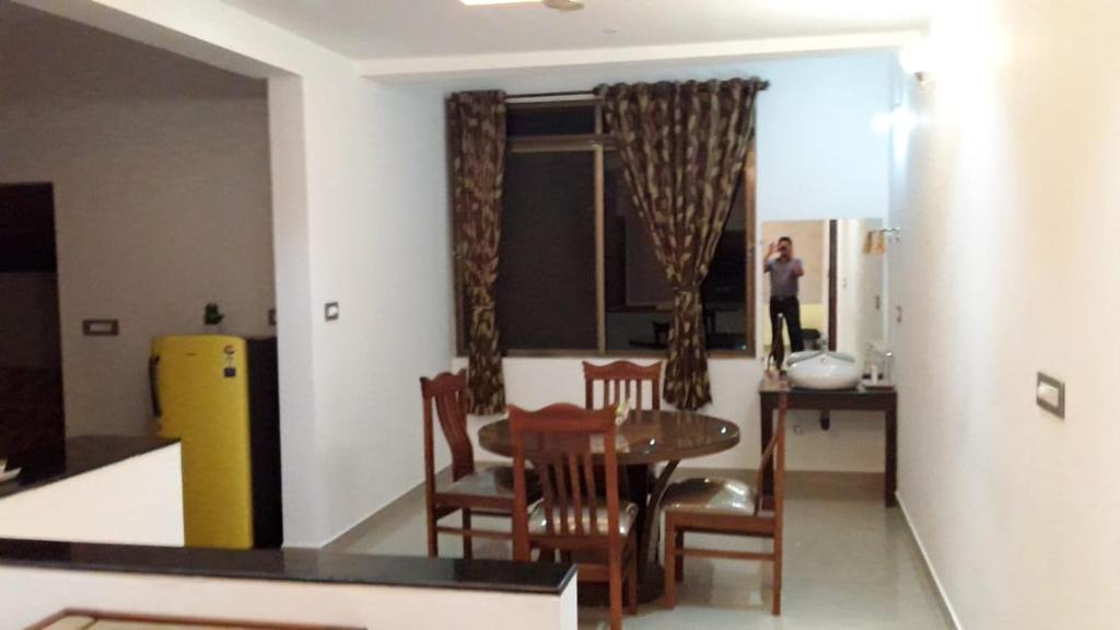 a kitchen and dining room with a table and chairs at Vamoose Mudra Midtown in Kalasa