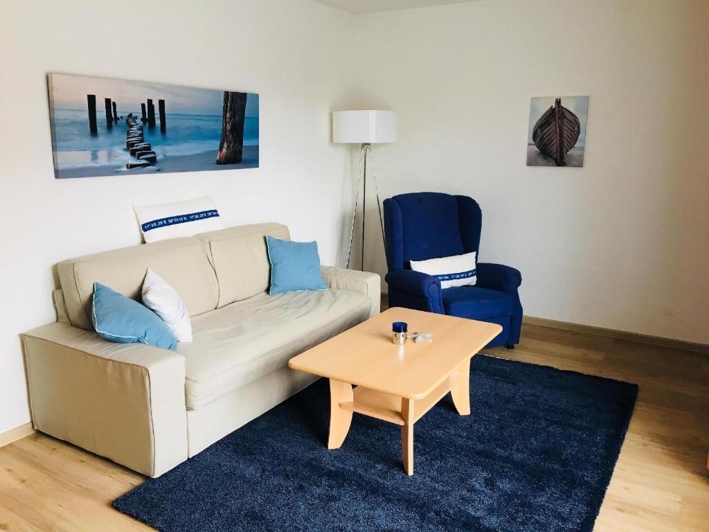 a living room with a couch and a table and a chair at Appartement-Konsulweg-KON-375 in Scharbeutz