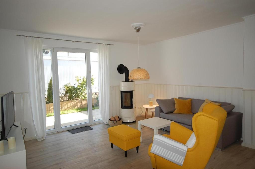 sala de estar con sofá y silla amarilla en Kiepenberg-9a-Scharbeutz-Kie-009, en Scharbeutz