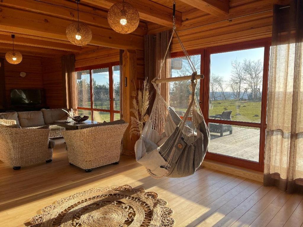 ein Wohnzimmer mit einer Hängematte in einer Hütte in der Unterkunft Sunset Beach House in Tūja