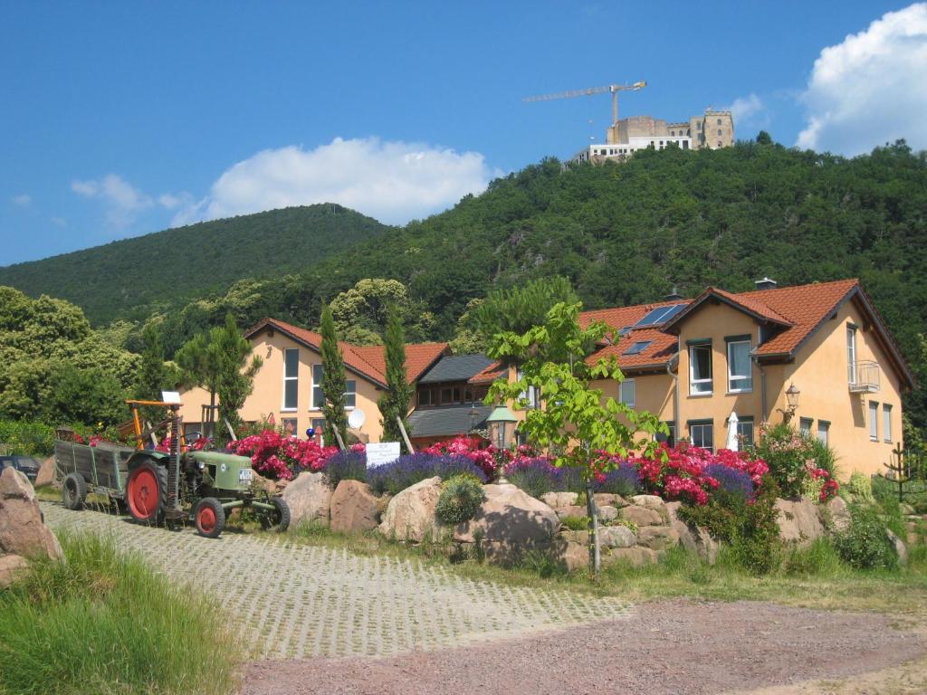 un tracteur garé devant une maison fleurie dans l'établissement Weinhaus Paradies, à Neustadt an der Weinstraße