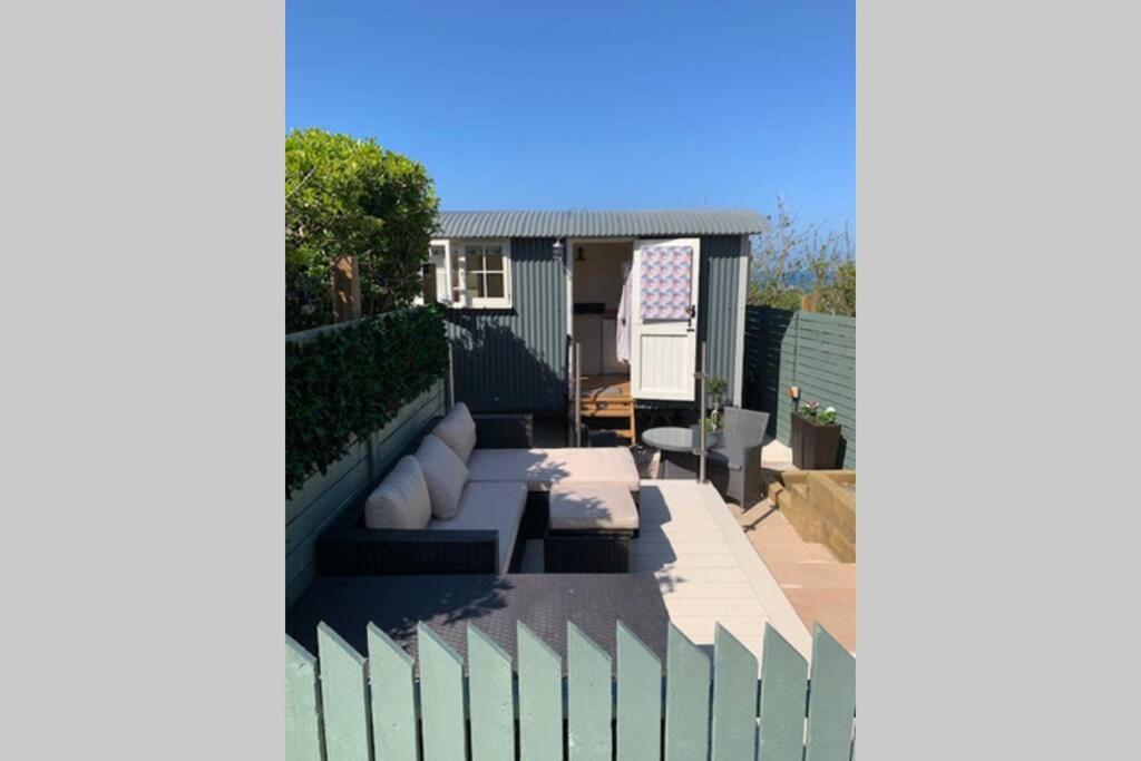 a backyard with a fence and a house at Trevone Luxury Shepherds hut close to the beach in Saint Merryn