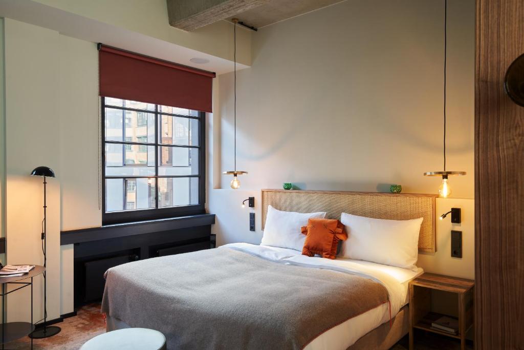 Un dormitorio con una cama grande y una ventana en hood house en Hamburgo