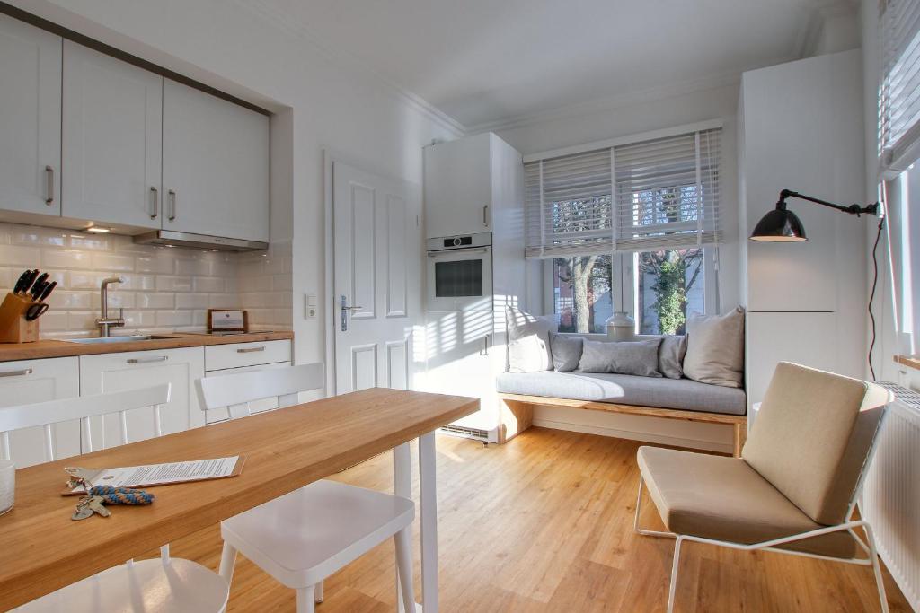 cocina y sala de estar con mesa y sofá en Landhaus am Ufer - Wohnung 1, en Heiligenhafen