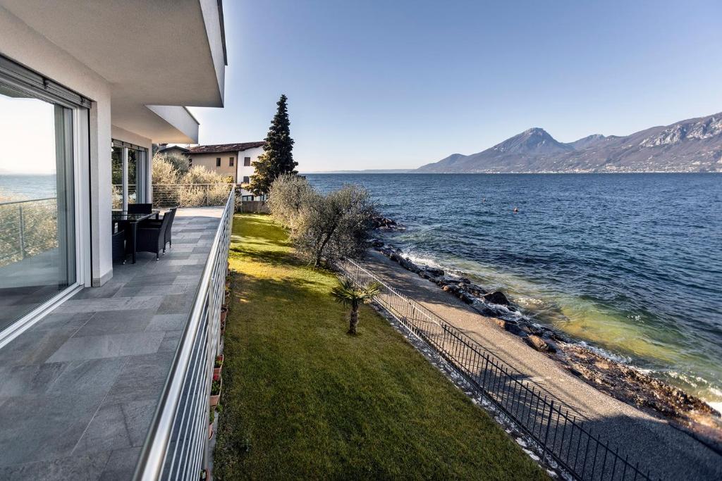 a balcony of a house with a view of the water at Villa Luthien in Brenzone sul Garda