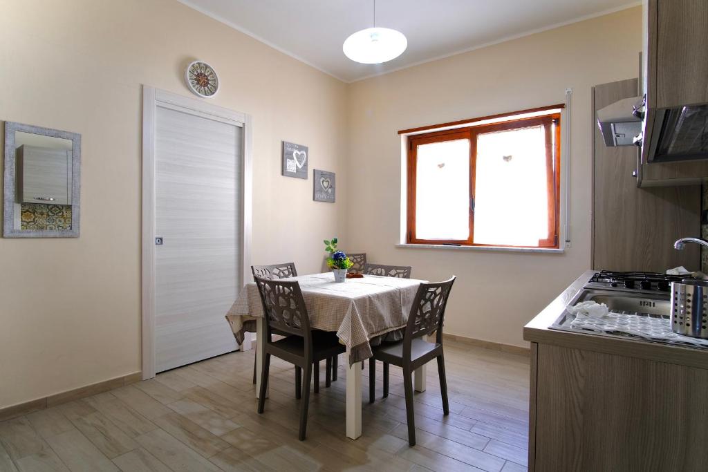 a kitchen and dining room with a table and chairs at La rosa dei venti, apartment 1 in Porto Empedocle